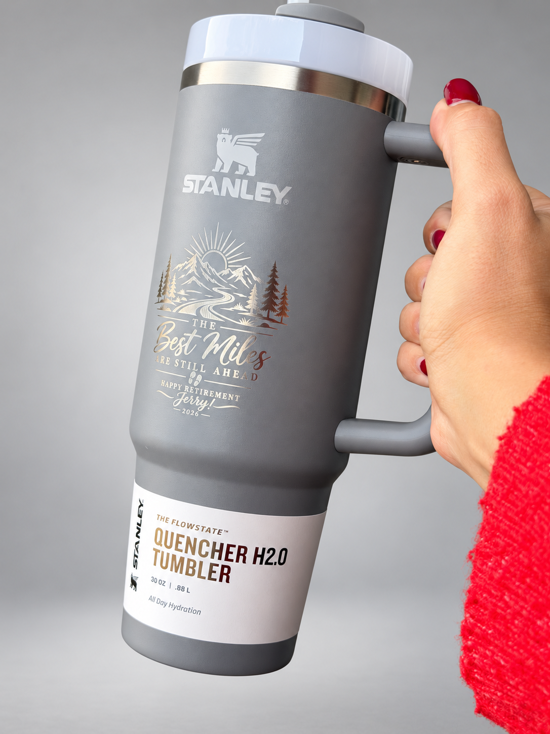 Angled view of custom engraved gray Stanley tumbler on a neutral studio background