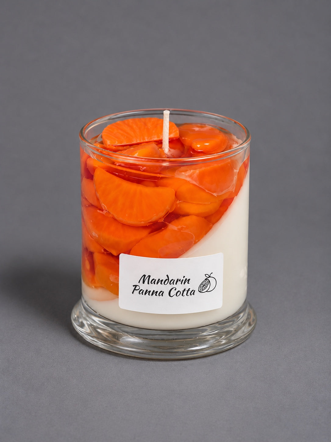 Mandarin Panna Cotta dessert candle with orange wax slices in a glass jar