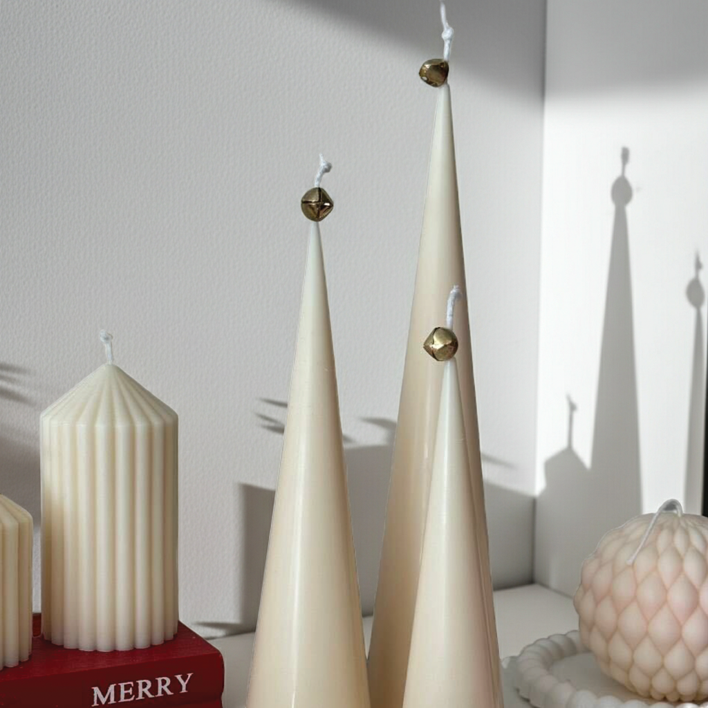Three ivory cone Christmas candles styled with decorative pillar and sphere candles