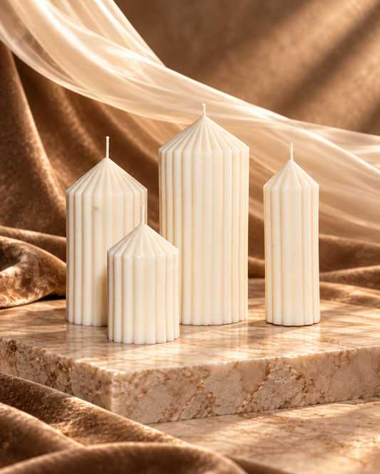 Four ivory ribbed pillar candles with pointed tops in graduated heights