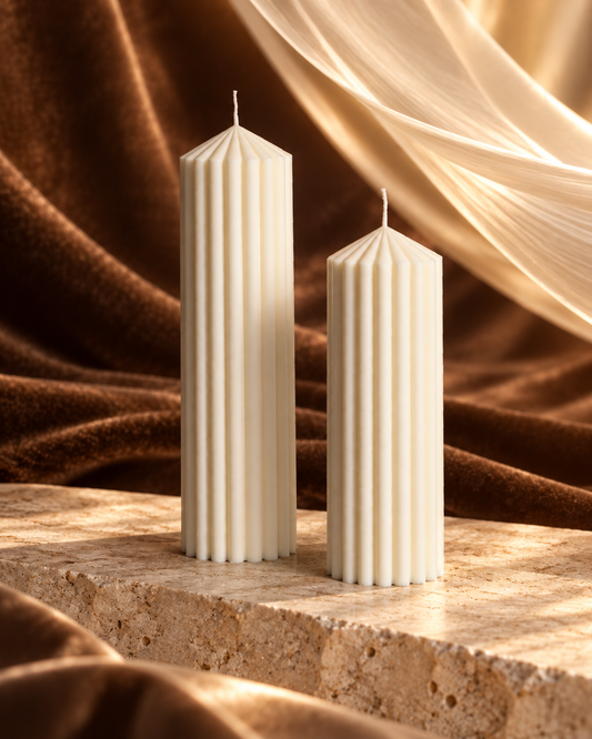 Two straight ivory ribbed table candles with pointed tops in different heights
