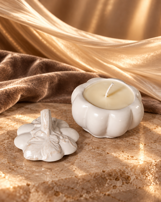 White ceramic pumpkin candle with its matching removable lid resting beside it