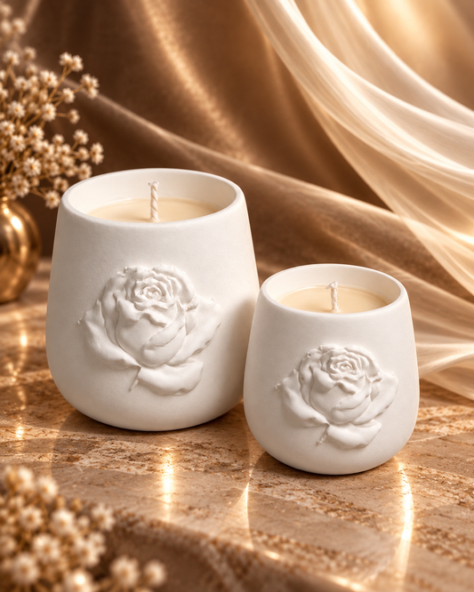 Two ivory candle vessels with raised rose details in 12 oz and 9 oz sizes